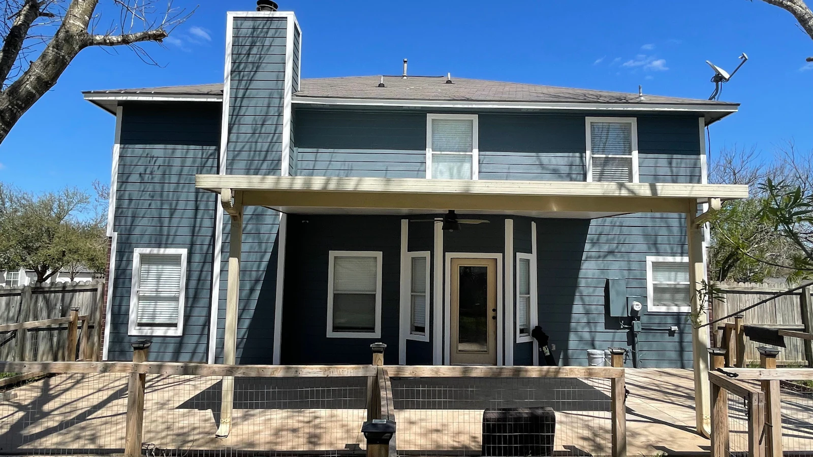 Two-story home with a freshly cleaned deck and pergola